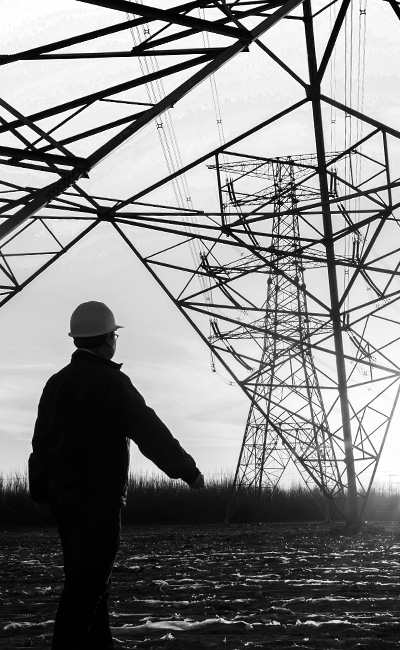 man standing under the transmission tower